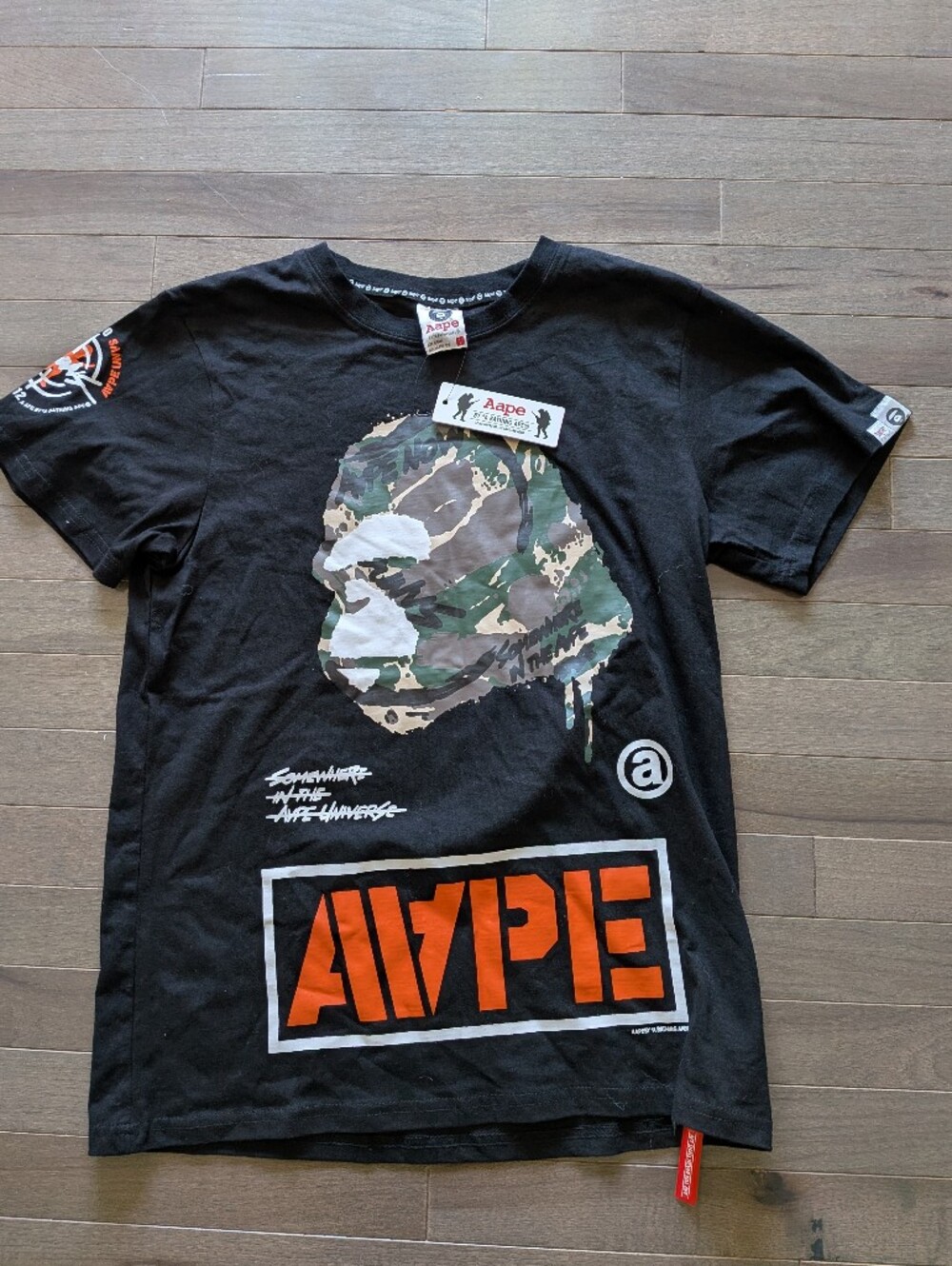 A Bathing Ape (BAPE) black cotton t-shirt with camouflage ape head graphic